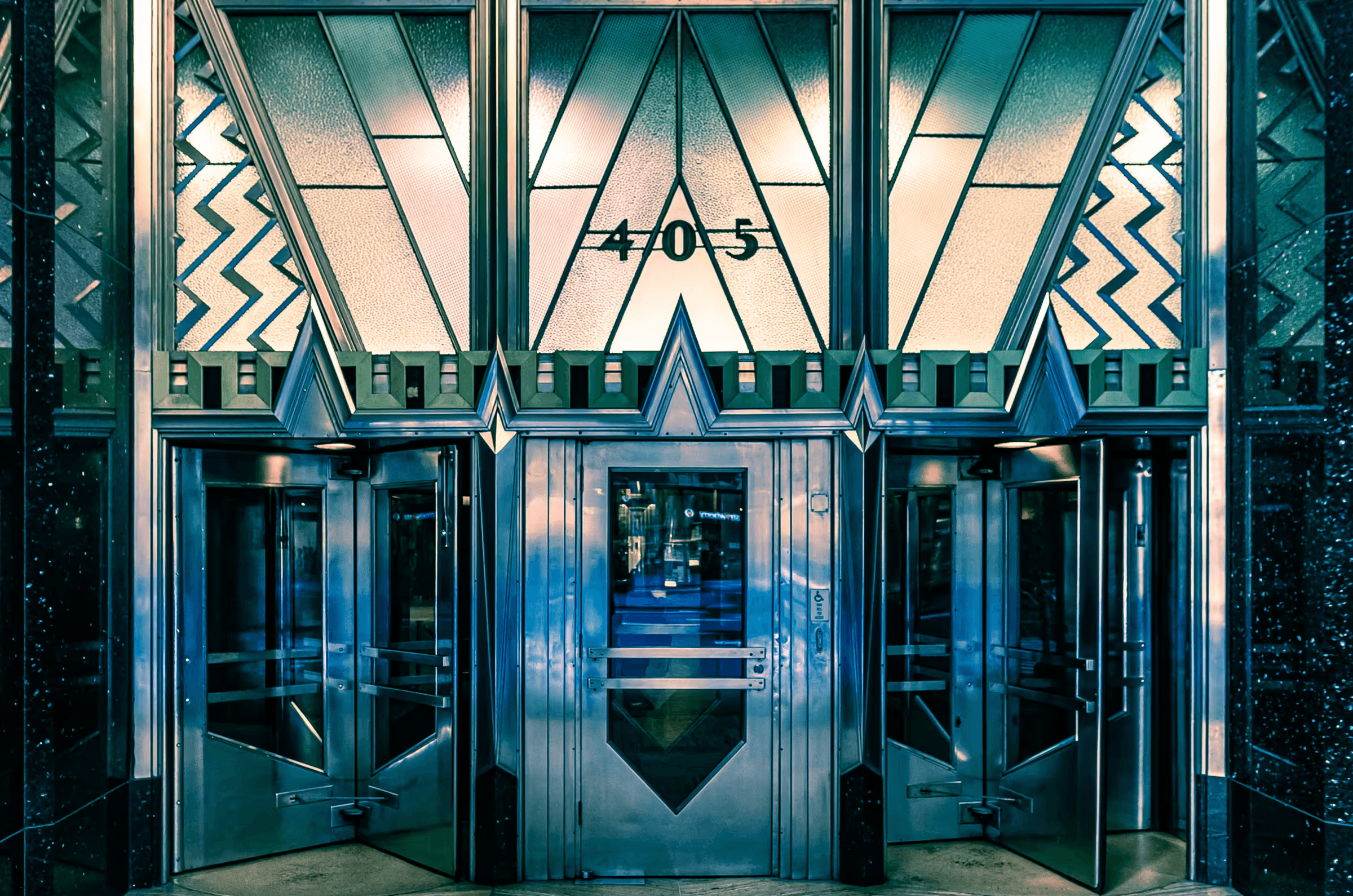 A detailed photograph of the Art Deco-style entrance doors of the Chrysler Building in Manhattan, New York City.