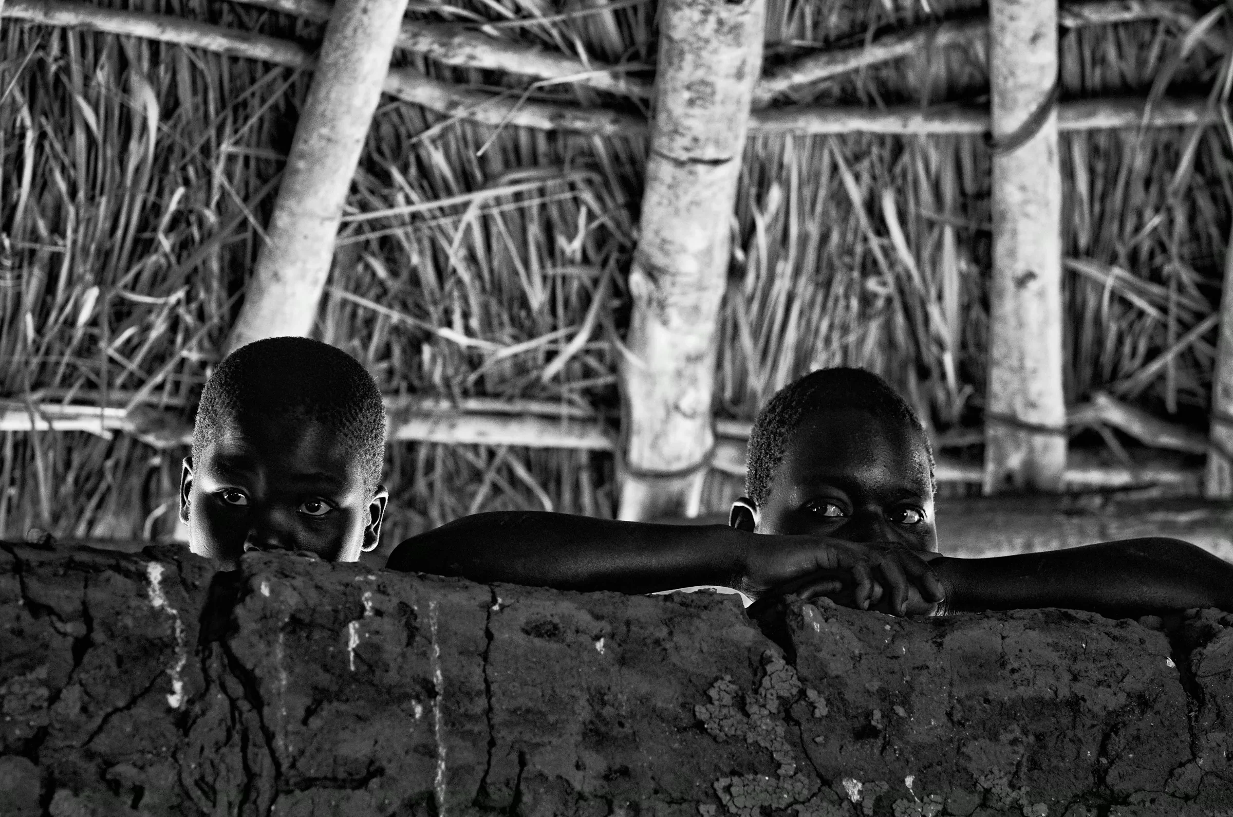 Peeking Over the Wall in a quiet portrait in North Uganda in monochrome.