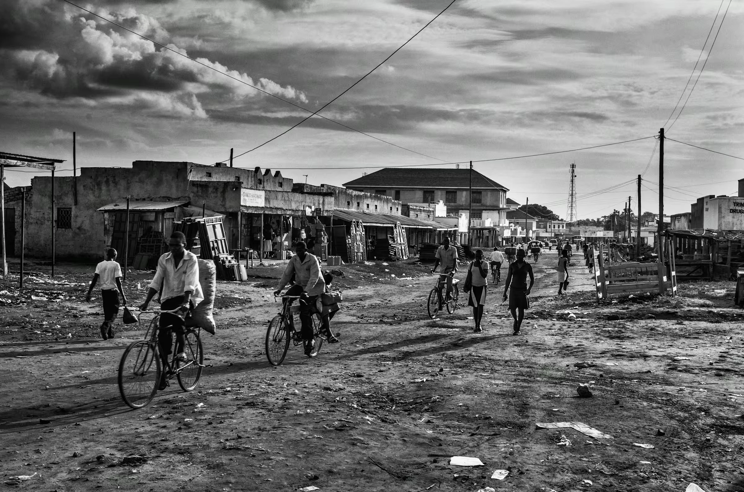 Black and white street scene photograph in a refugee settlement in Northern Uganda.