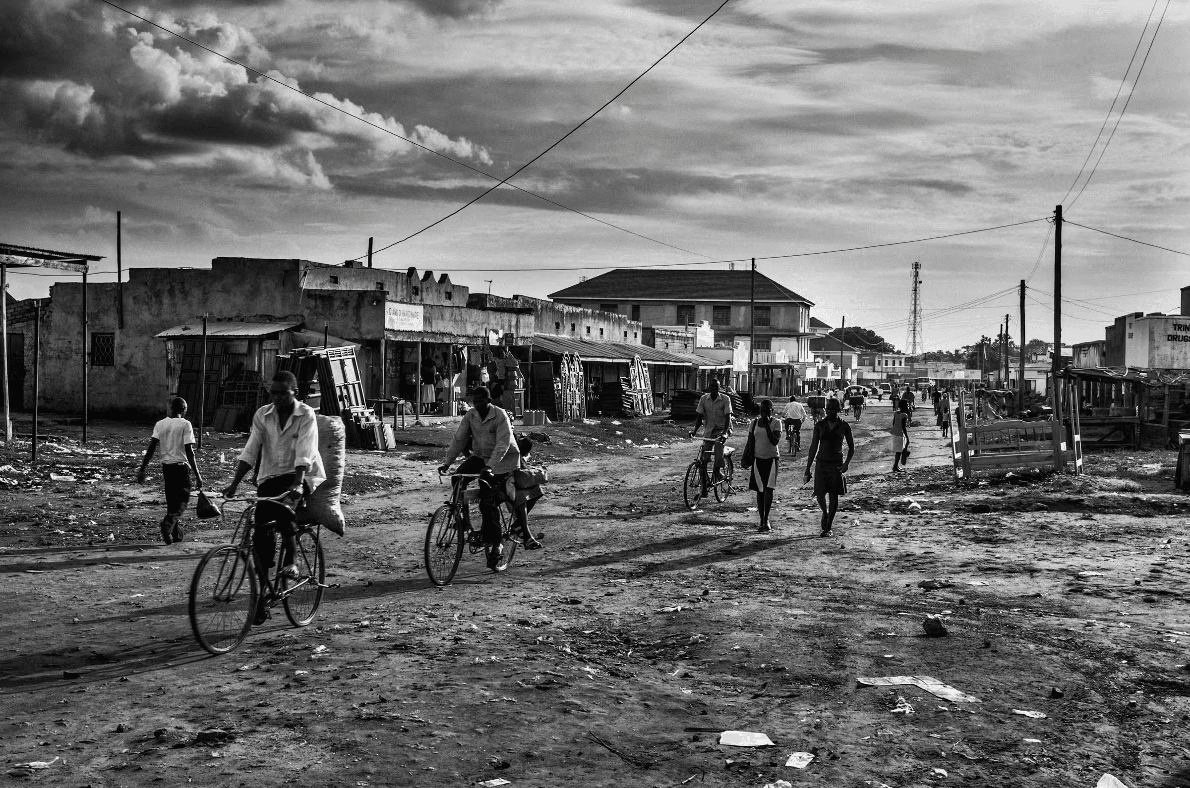 Black and white street scene photograph in a refugee settlement in Northern Uganda.