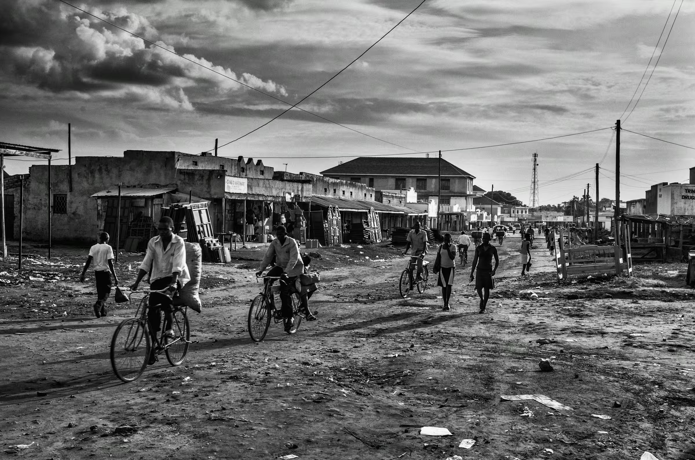 Black and white street scene photograph in a refugee settlement in Northern Uganda.