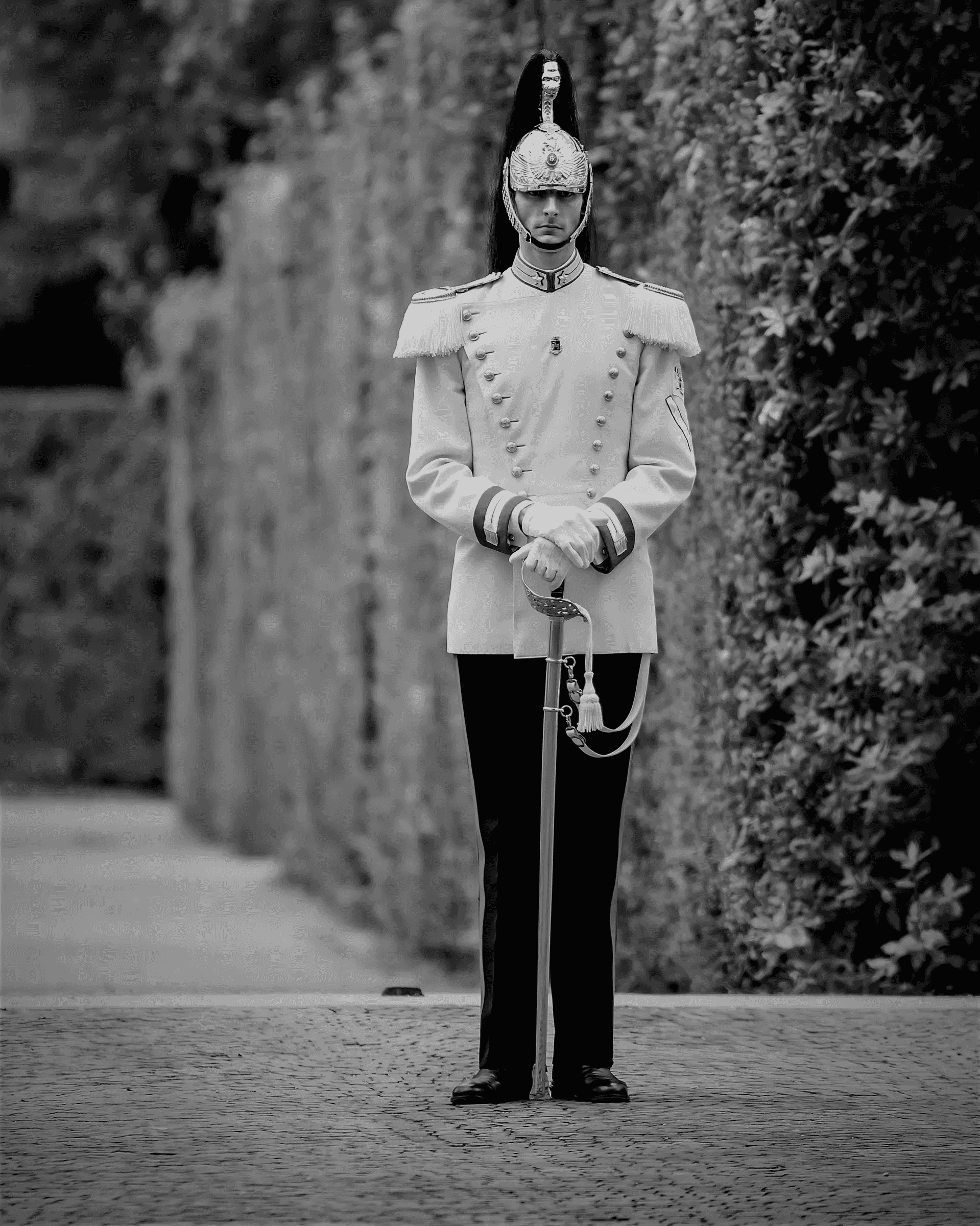Black and white photograph of a Cuirassier standing at attention, guarding the Quirinal Palace in Rome, Italy.
