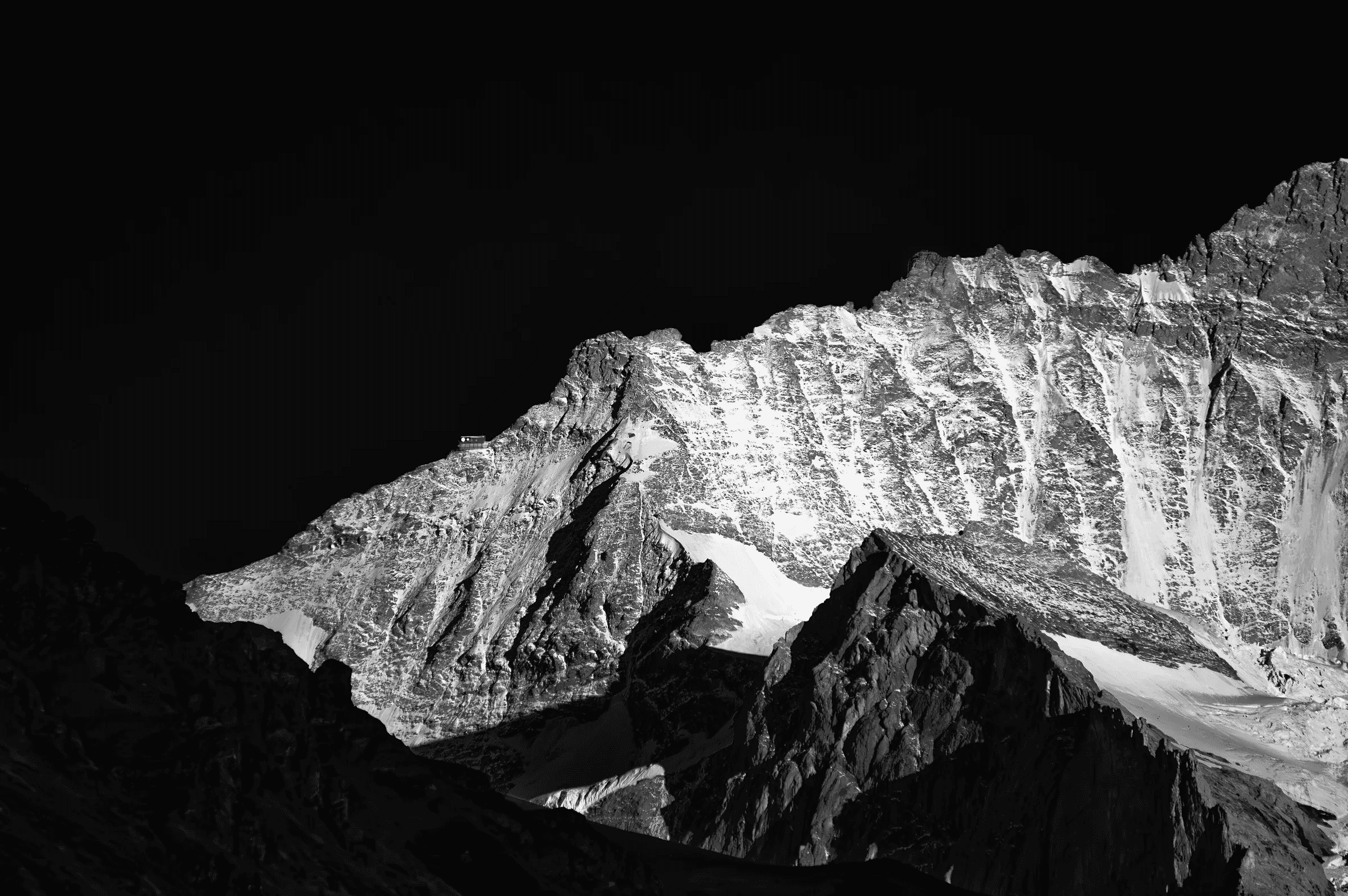 Swiss Alps Peaks in Stark Contrast High-contrast black and white study of snow-dusted Swiss Alps peaks against a dark sky.