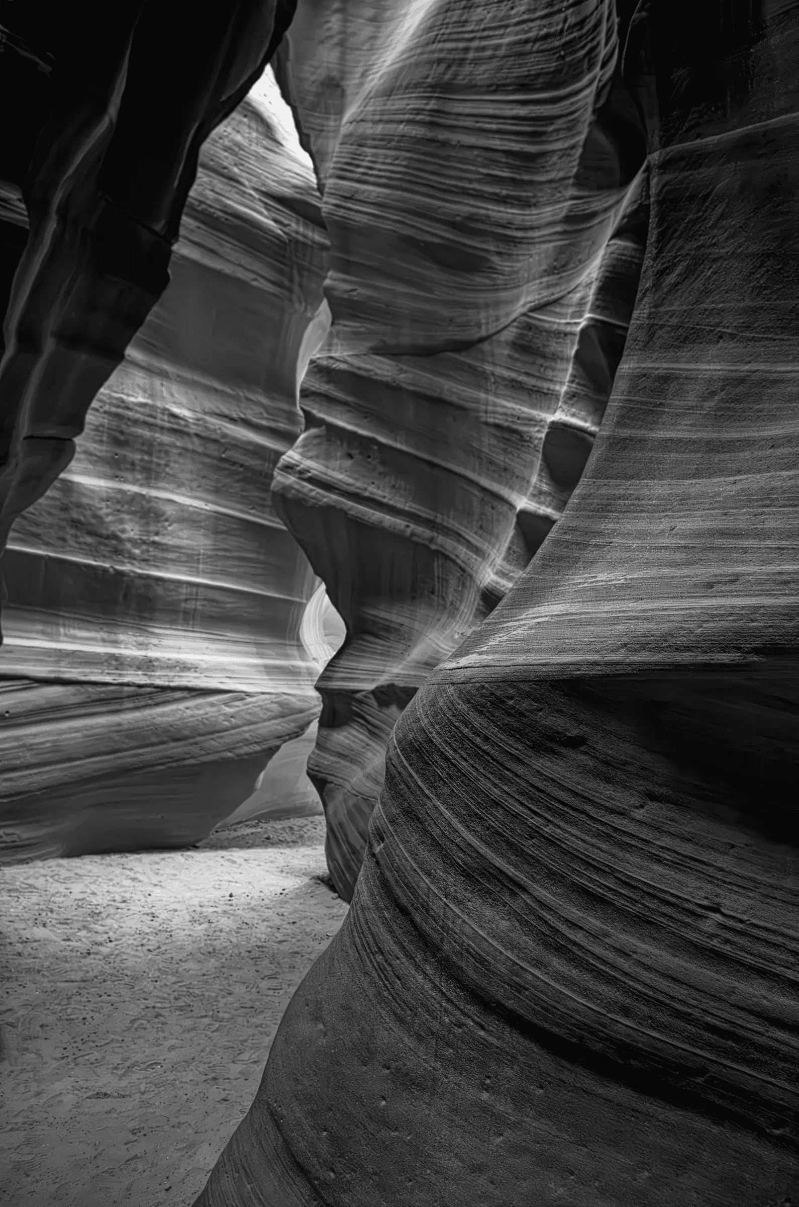 Monochrome view through the layered, curving sandstone walls of Antelope Canyon in Arizona.