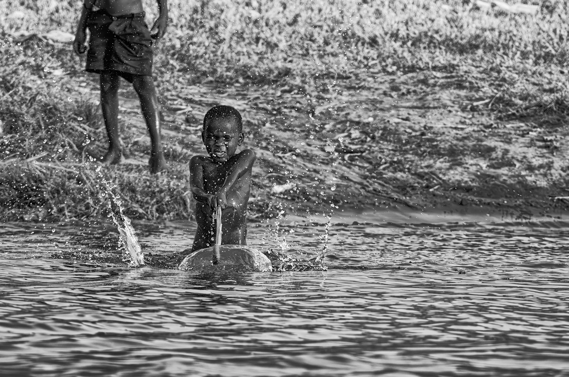 Splashing Fun in Uganda in daily life in monochrome.