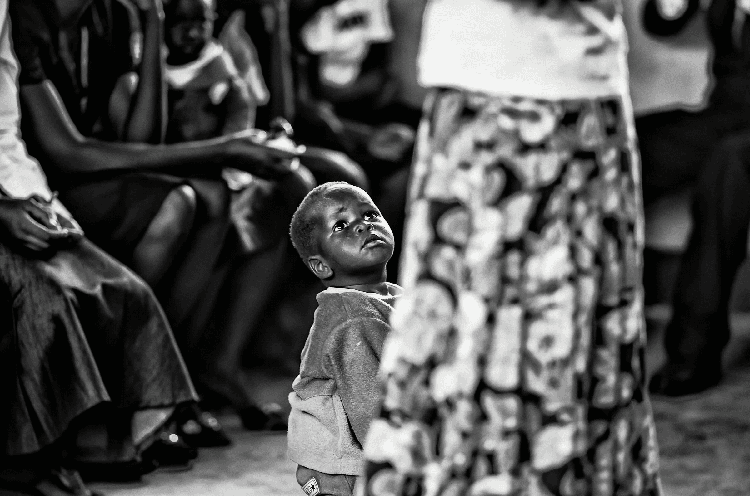 Click to view in fullscreen Child Looking Up in a quiet portrait in Uganda in monochrome.