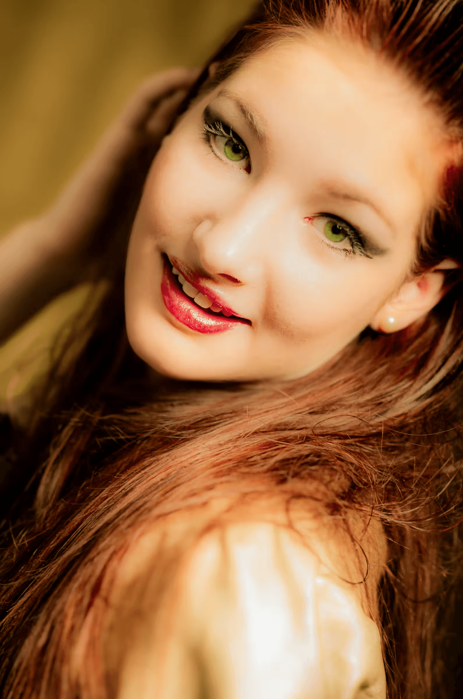 A young woman with long, flowing auburn hair and striking green eyes.